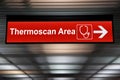 Thermoscan Area red sign with arrow direction hang from ceiling at the airport for outbreak control situation at passengers Royalty Free Stock Photo