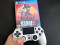 Thessaloniki, Greece, February 11, 2020: The New Red Dead Redemption 2 game with ps4 v2 white Joystick on black