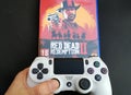 Thessaloniki, Greece, February 11, 2020: The New Red Dead Redemption 2 game with ps4 v2 white Joystick on black