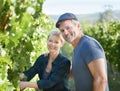 Theyre avid farmers. Happy mature couple checking the vines in their vineyard together.