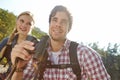 Theyre both avid birdwatchers. A young couple out in nature looking around while holding their binoculars.