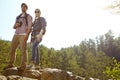 Theyre both avid hikers. A young couple standing atop a moutain and taking into the view.