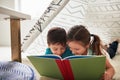 Theyre hooked to the story. two adorable young siblings reading a book together at home. Royalty Free Stock Photo