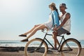 Theyre just cool like that. a young couple riding a bicycle together on the promenade.