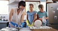 Theyre learning from the best. an affectionate young mother doing the dishes with her two children in their kitchen at Royalty Free Stock Photo