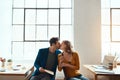 Theyre lucky they work together. young couple kissing while working together in their modern office. Royalty Free Stock Photo