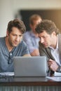 Theyre movers and shakers in the app world. colleagues working together on a laptop in a modern office.