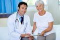 Theyre pleased with the results. Portrait of a handsome young doctor going through a chart with a senior patient. Royalty Free Stock Photo