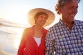 Theyre romantics at heart. a mature couple enjoying a late afternoon walk on the beach. Royalty Free Stock Photo