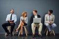 Theyve got a friendly rivalry. Full length shot of a group of businesspeople waiting in line for a job interview. Royalty Free Stock Photo