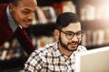 Theyve partnered up on their next assignment. two university students working together on a computer in the library on Royalty Free Stock Photo