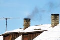 Thick and black smoke comes out of the chimney of an old private house. Royalty Free Stock Photo