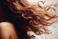 Thick brown curly well groomed female hair flutters in wind close up