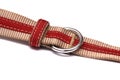 A thick canvas material fabric belt with red inner strap buckle and loop white backdrop Royalty Free Stock Photo