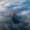 Thick clouds of autumn fog and the Motherland monument sticking out of them Royalty Free Stock Photo