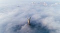 Thick clouds of autumn fog and the Motherland monument sticking out of them Royalty Free Stock Photo