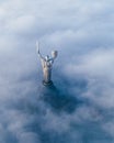 Thick clouds of autumn fog and the Motherland monument sticking out of them Royalty Free Stock Photo