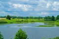 Thick clouds float over the lake. There`s a haystack in the background. Royalty Free Stock Photo