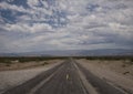 Thick clouds over badly asphalted road Royalty Free Stock Photo