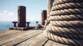 Close-up Coil of Thick Marine Rope on Wooden Dock with Bollards and Ocean Background Royalty Free Stock Photo