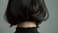 The thick dark hair lining the nape of a neck creating a striking contrast against a pale neckline.