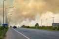 Thick dark smoke from a fire at side of road Royalty Free Stock Photo
