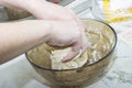 Thick dough is manually mixed in a transparent bowl