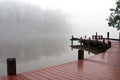 Thick Fog Covers Wooden Dock And Lake On Winter Day