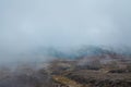 Thick fog creeping over desolated lava fields on the slopes of Mt Ruapehu. Tongariro National Park, New Zealand