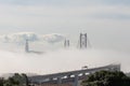 Thick fog envelops the bridge - people run a marathon on the bridge Royalty Free Stock Photo