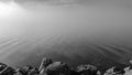 Thick fog on lake. Monochrome misty water.