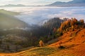 Thick fog, like milk, covered the valley, behind which rise mountain hills, on which fall warm rays of the sun. Royalty Free Stock Photo