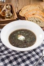 Thick forest mushroom soup with potatoes on fabric napkin on wooden table