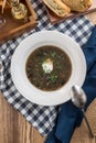 Thick forest mushroom soup with potatoes on fabric napkin on wooden table