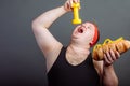 Funny guy in sportswear eat small dumbbells Royalty Free Stock Photo