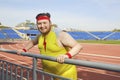 Thick funny man resting after a workout at the stadium.