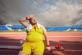 Thick funny man resting after a workout at the stadium.