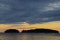 Thick, gray clouds at sunset over lake and islands in the water Royalty Free Stock Photo