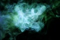 Thick green and blue smoke on a black isolated background.