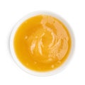 Thick honey in dark bowl on white background. Top view