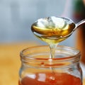 Thick honey drips from the spoon