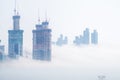 Thick large and heavy mist blow from the sea to the land and pass through skyscrapers and cover all other buildings in the area. Royalty Free Stock Photo