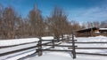 Thick layers of snow lie on an old unpainted wooden fence.