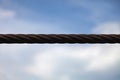 Thick metal cable on a blue background with texture. Abstraction of heavy industry