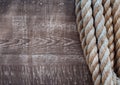 Thick rope on a background of old wooden boards in grunge style. The concept. Old American cowboy, ranch, lasso. Background for de Royalty Free Stock Photo