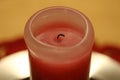 Half-Burned Thick Pink and Red Wax Candle in a Closeup Royalty Free Stock Photo