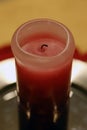 Half-Burned Thick Pink and Red Wax Candle in a Closeup Royalty Free Stock Photo