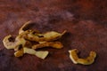 Thick potato peelings on a rusty textured surface.