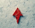 Minimalist thick red arrow pointing down on light grey canvas with subtle shadow, conveying descent Royalty Free Stock Photo