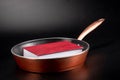 Thick red book in a pan the background is dark Royalty Free Stock Photo